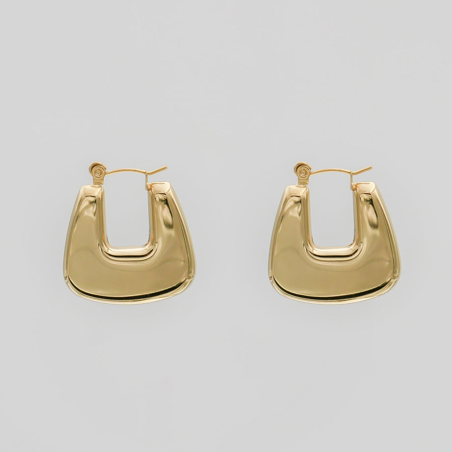 Gold geometric hoop earrings on white background.