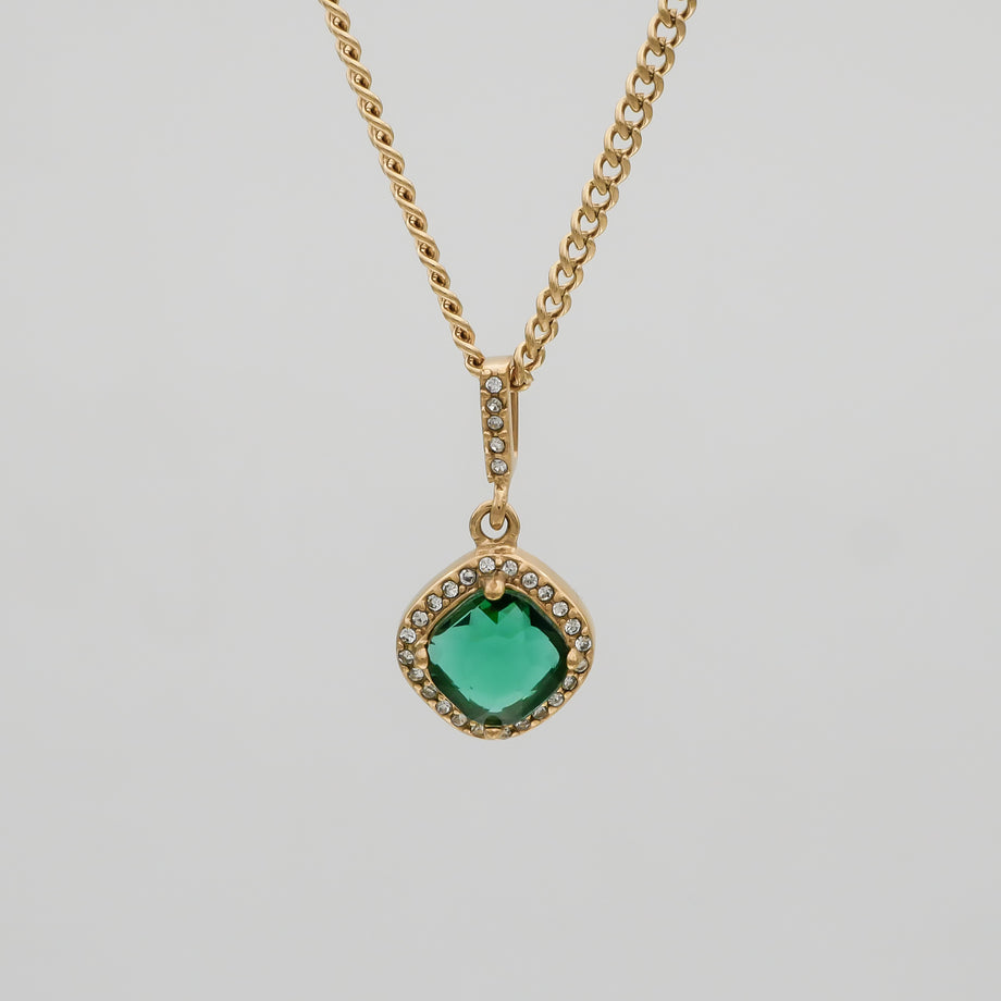 Gold necklace with green gemstone pendant.