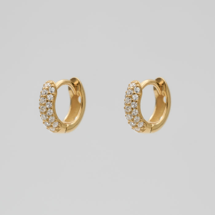 Gold hoop earrings with sparkling gemstones.