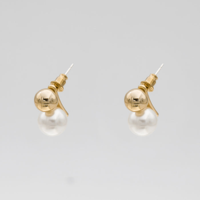 Gold and pearl stud earrings on white background.