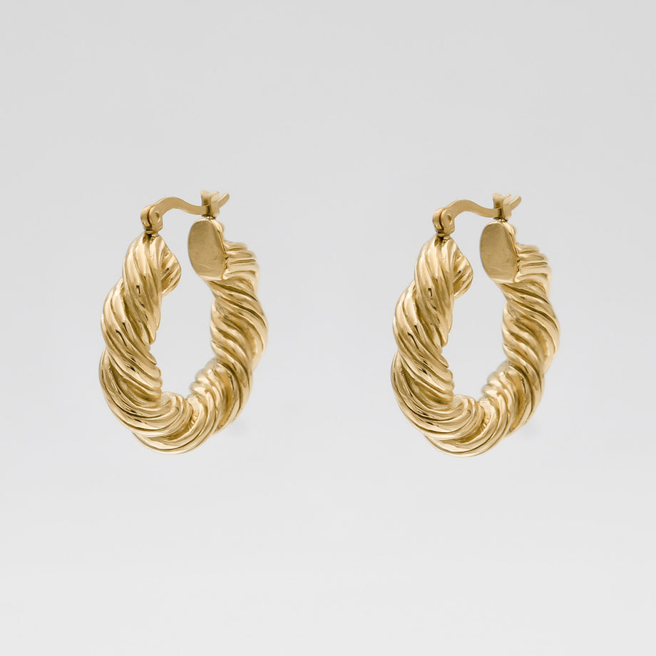 Gold twisted hoop earrings on white background.