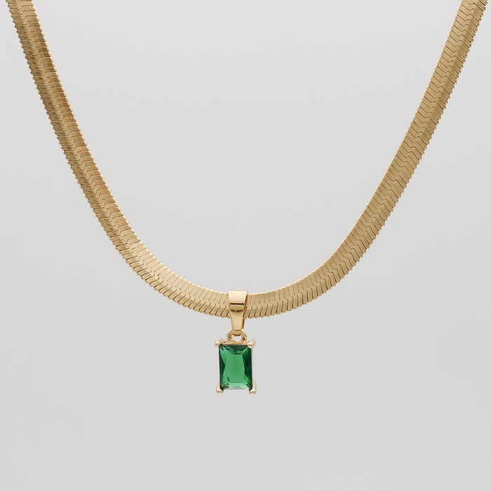 Gold necklace with green gemstone pendant.