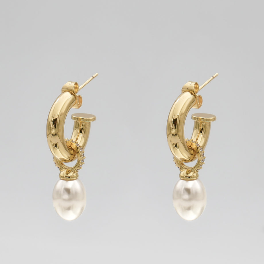 Gold hoop earrings with pearl drops.