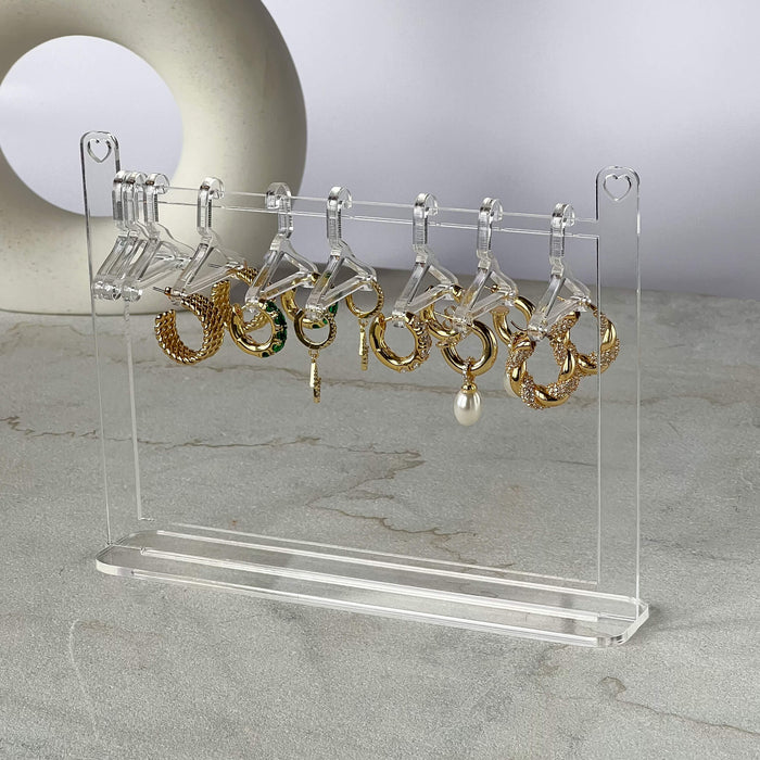 Clear earring hanger with gold hoop earrings.