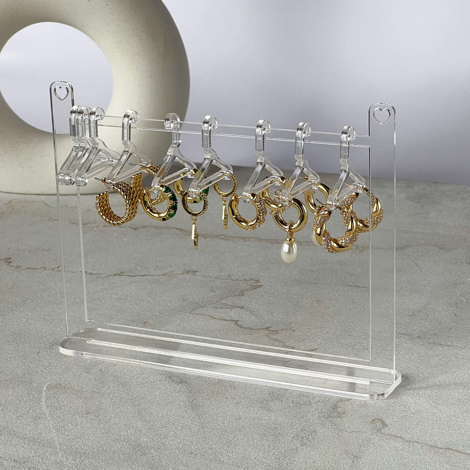 Clear earring hanger with gold hoop earrings.