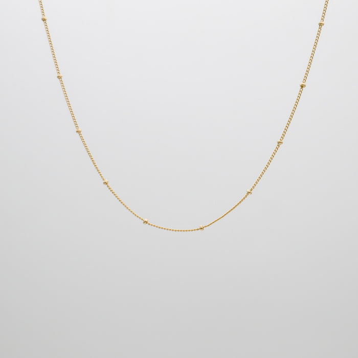 Gold chain necklace on white background.