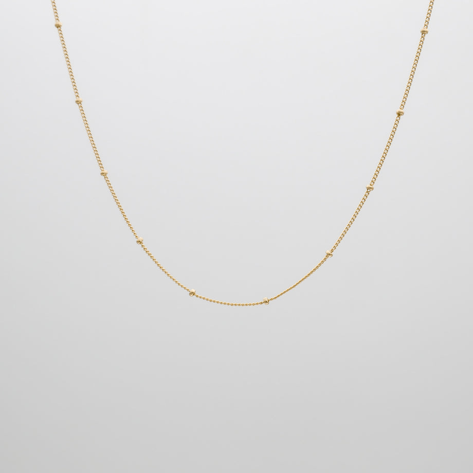 Gold chain necklace on white background.