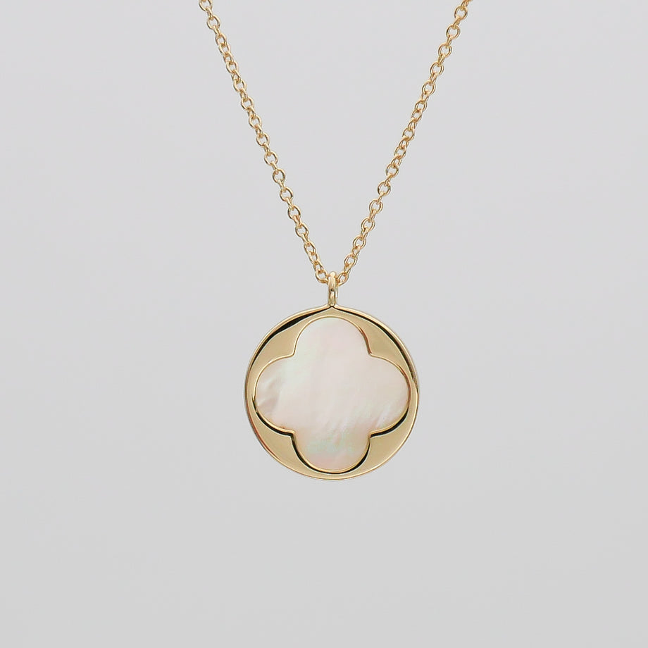 Gold necklace with clover-shaped pendant.