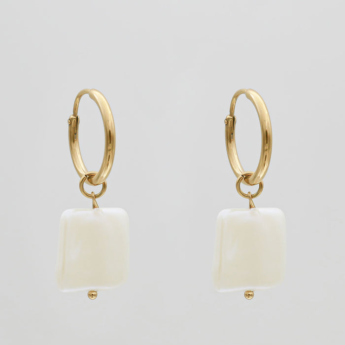 Gold hoop earrings with white square pendants.