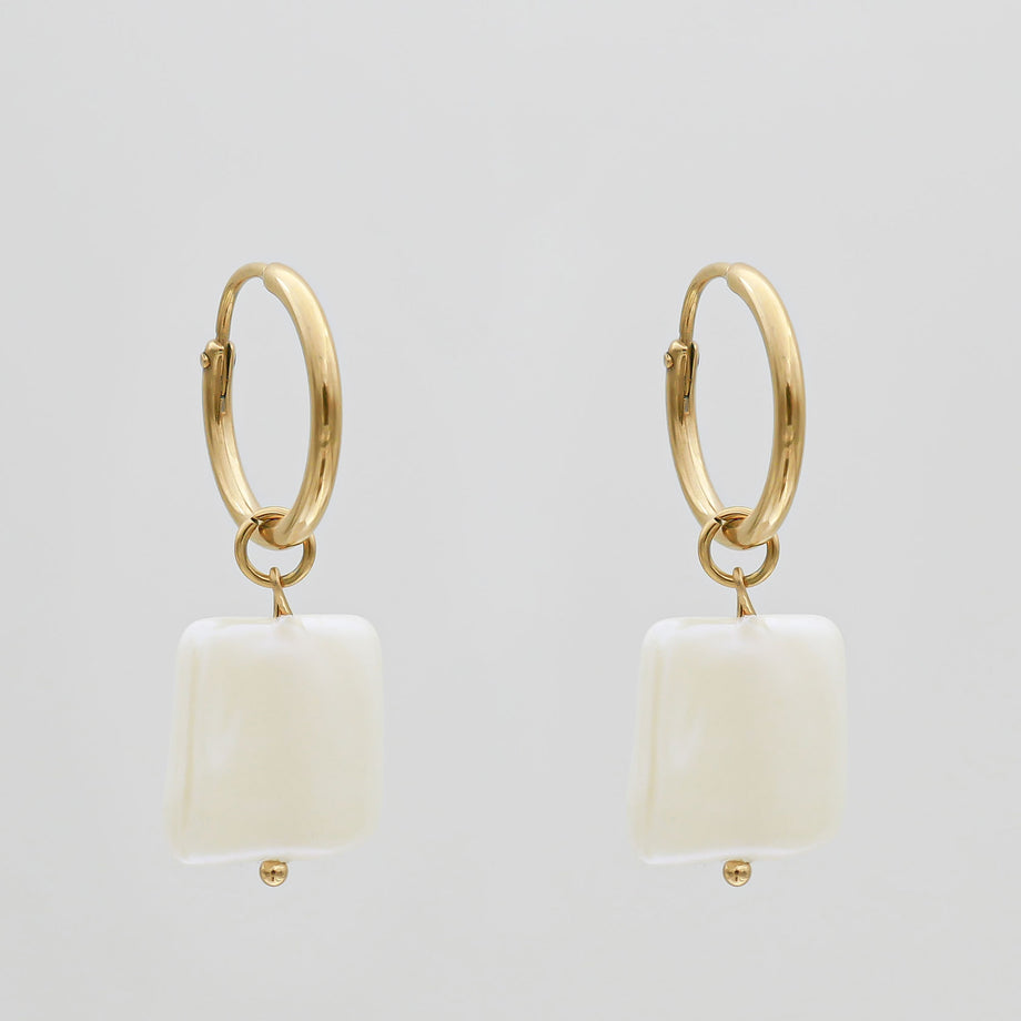 Gold hoop earrings with white square pendants.