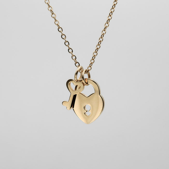 Gold necklace with heart and key pendants.