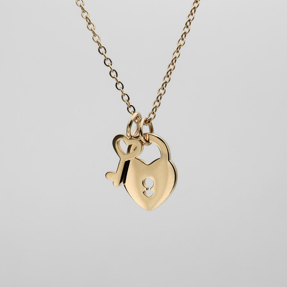 Gold necklace with heart and key pendants.