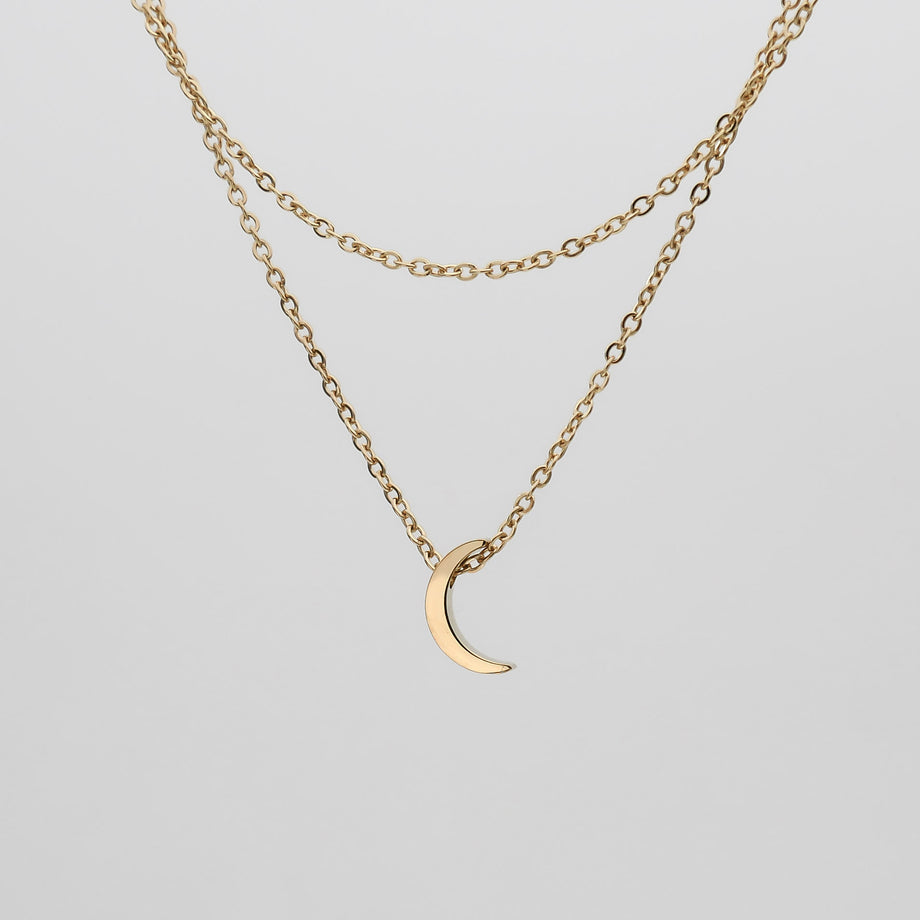 Gold crescent moon necklace with dual chains.