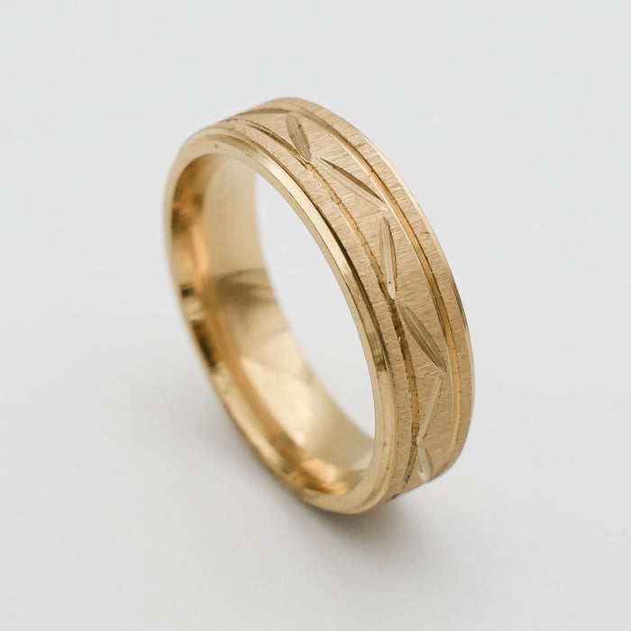 Gold ring with engraved geometric pattern.