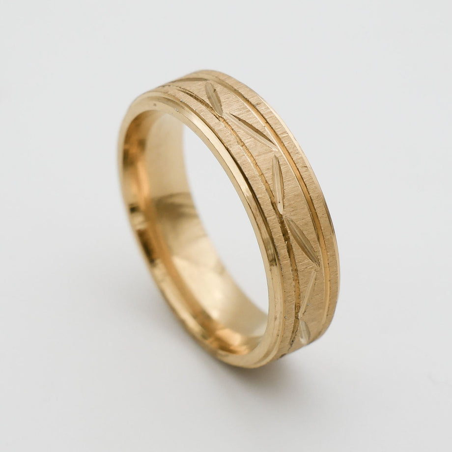 Gold ring with engraved geometric pattern.