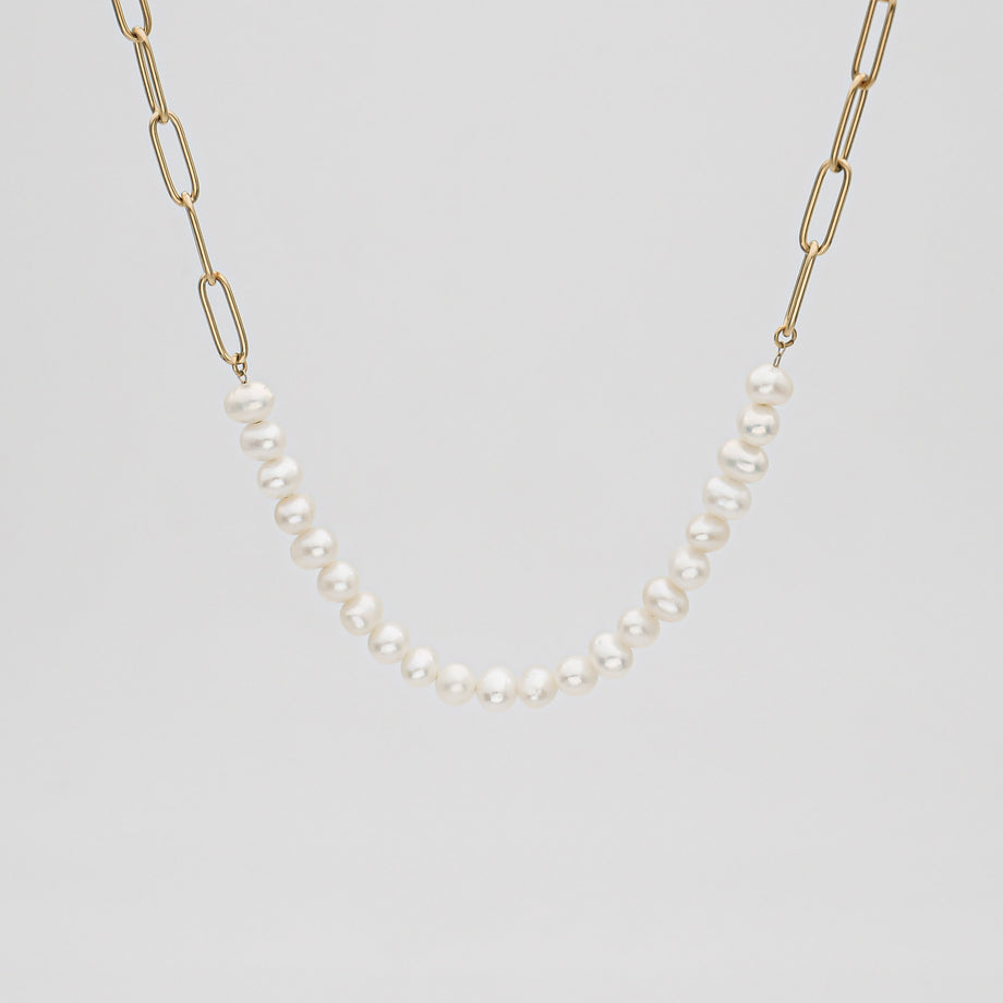 Gold chain necklace with white pearls.