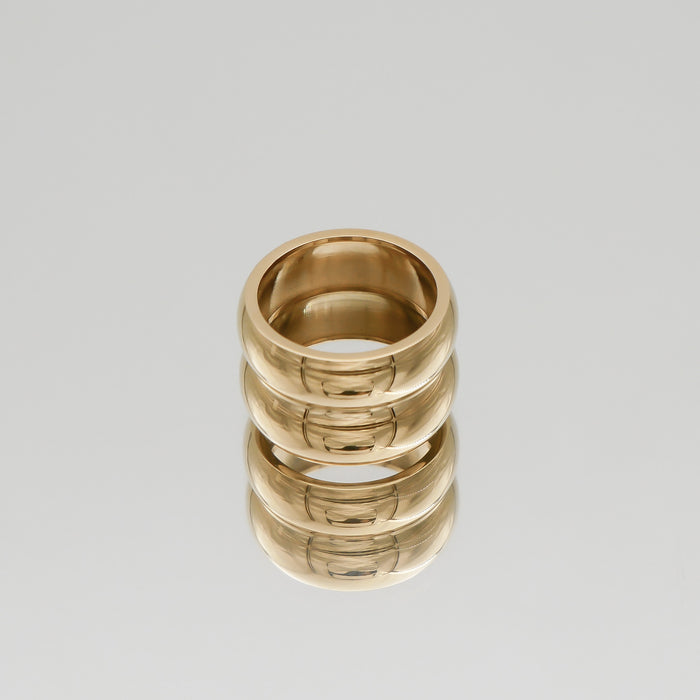 Gold double band ring on reflective surface.