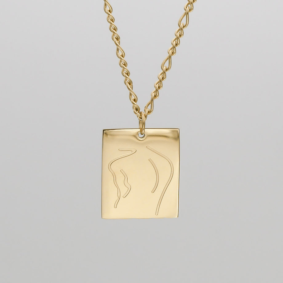 Gold necklace with abstract engraved pendant.