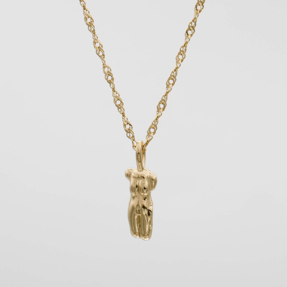 Gold necklace with abstract pendant design.