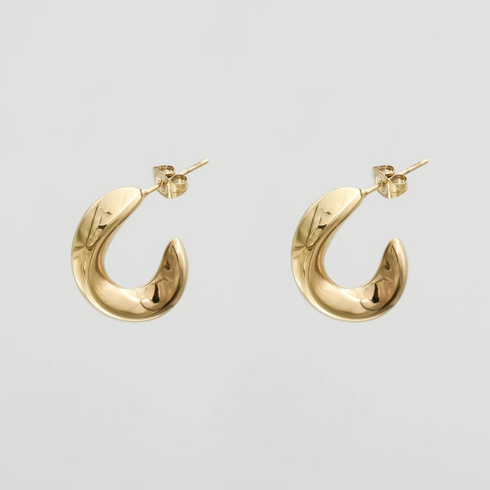 Gold crescent-shaped earrings on white background.