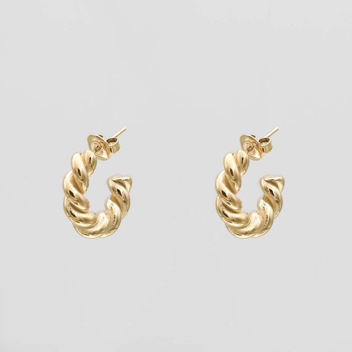 Gold twisted hoop earrings on a white background.