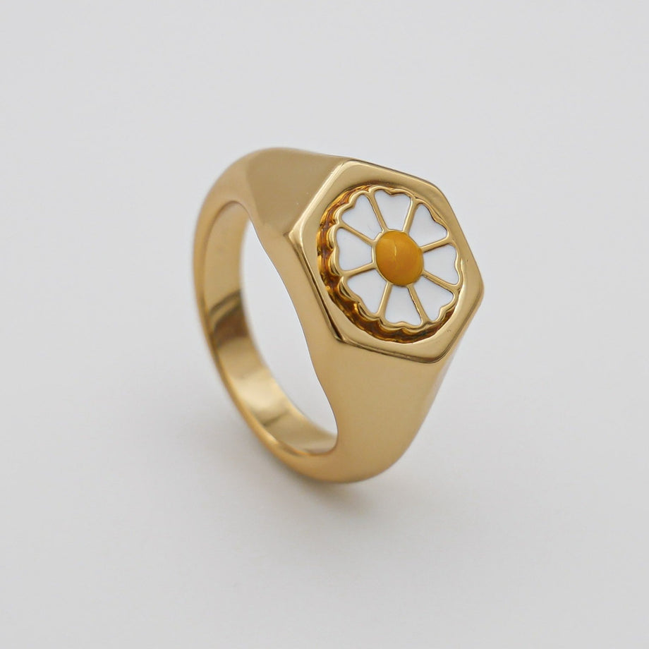 Gold ring with enamel daisy design.