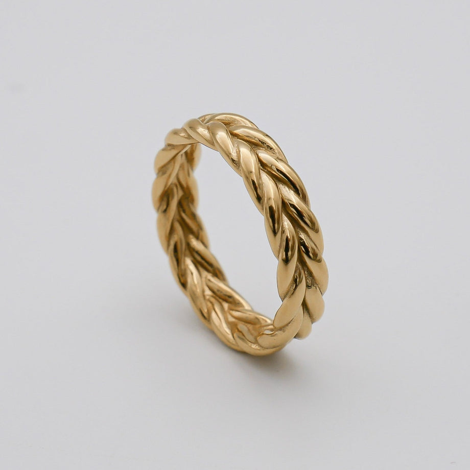 Gold twisted rope design ring on white background.