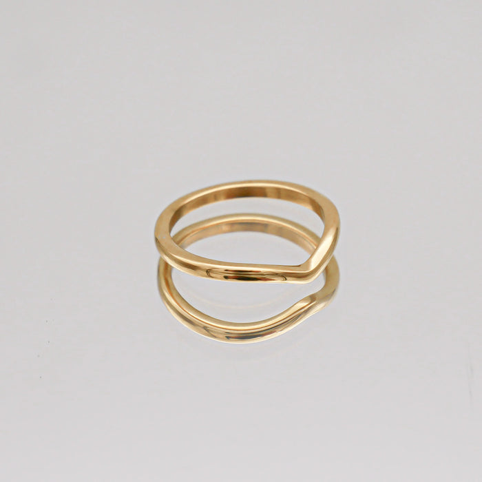 Gold PRYA ring on reflective surface.