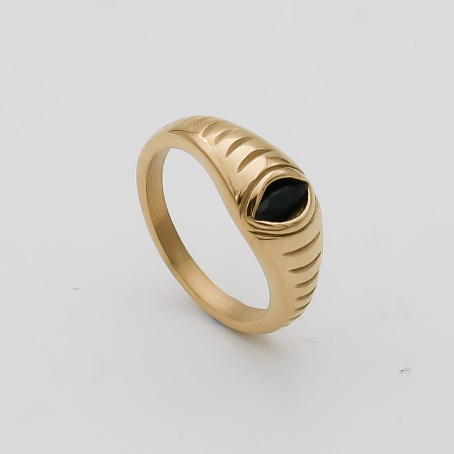 Gold ring with black gemstone and engraved details.