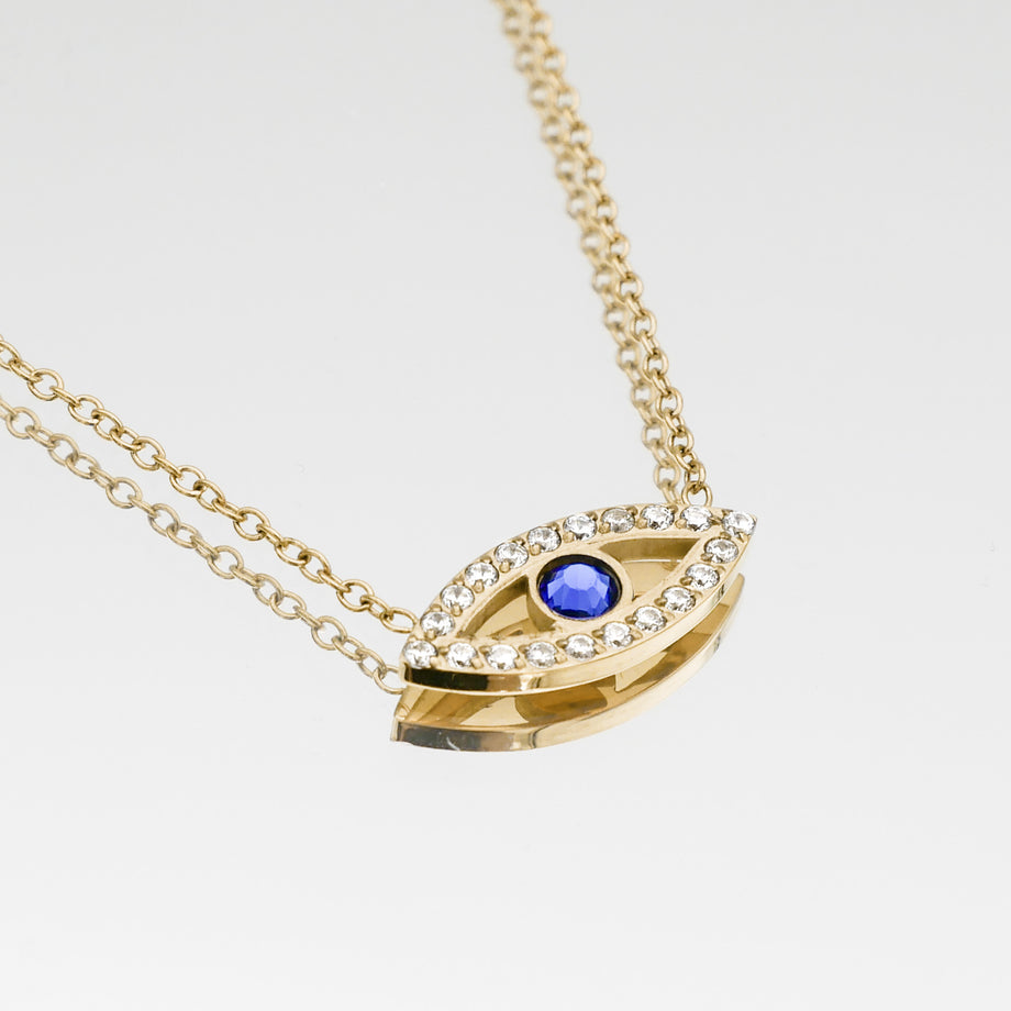 close up of gold evil eye necklace with  paved cz stones and blue stone centre