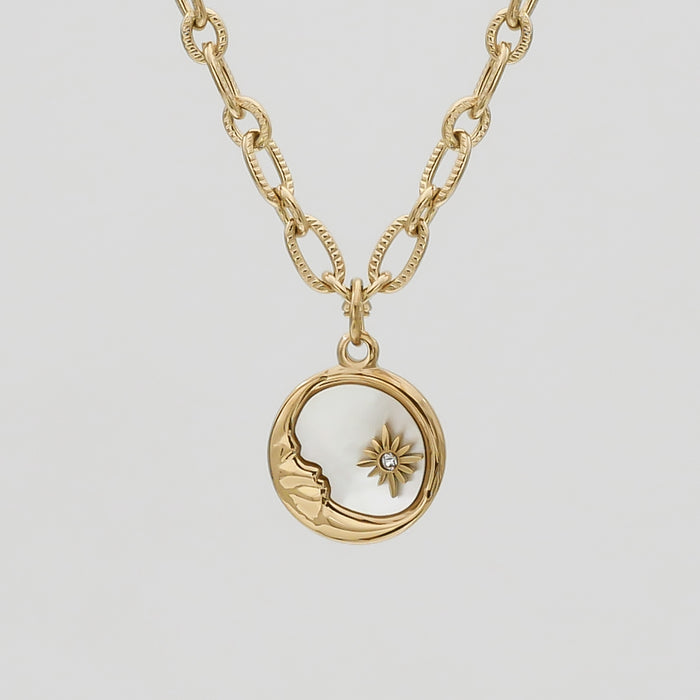 Gold necklace with moon and star pendant.