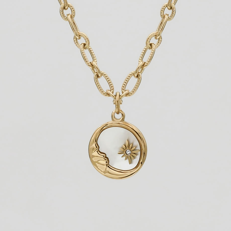 Gold necklace with moon and star pendant.