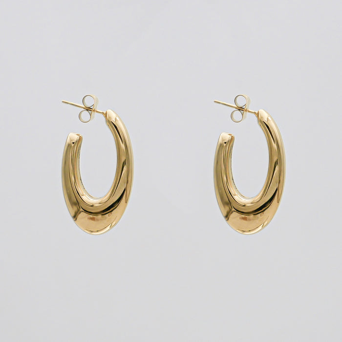 Gold oval hoop earrings on white background.