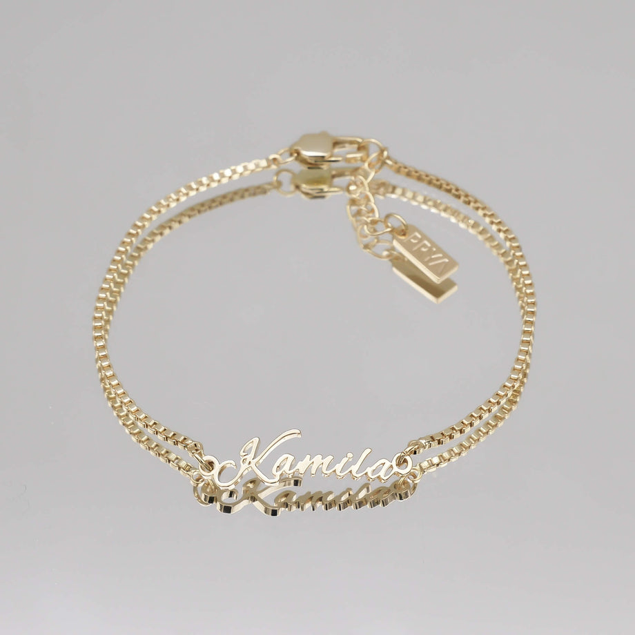 Gold name bracelet with double chain.