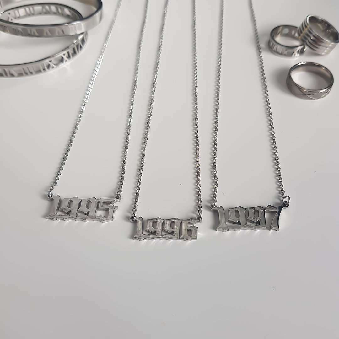 A selection of three silver birth year necklaces featuring the years 1995, 1996 and 1997.