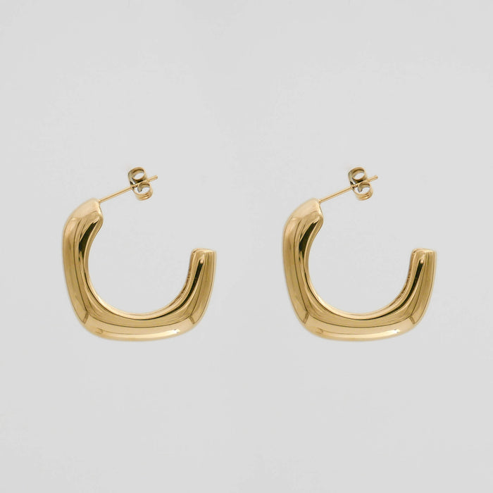 Gold hoop earrings on a white background.