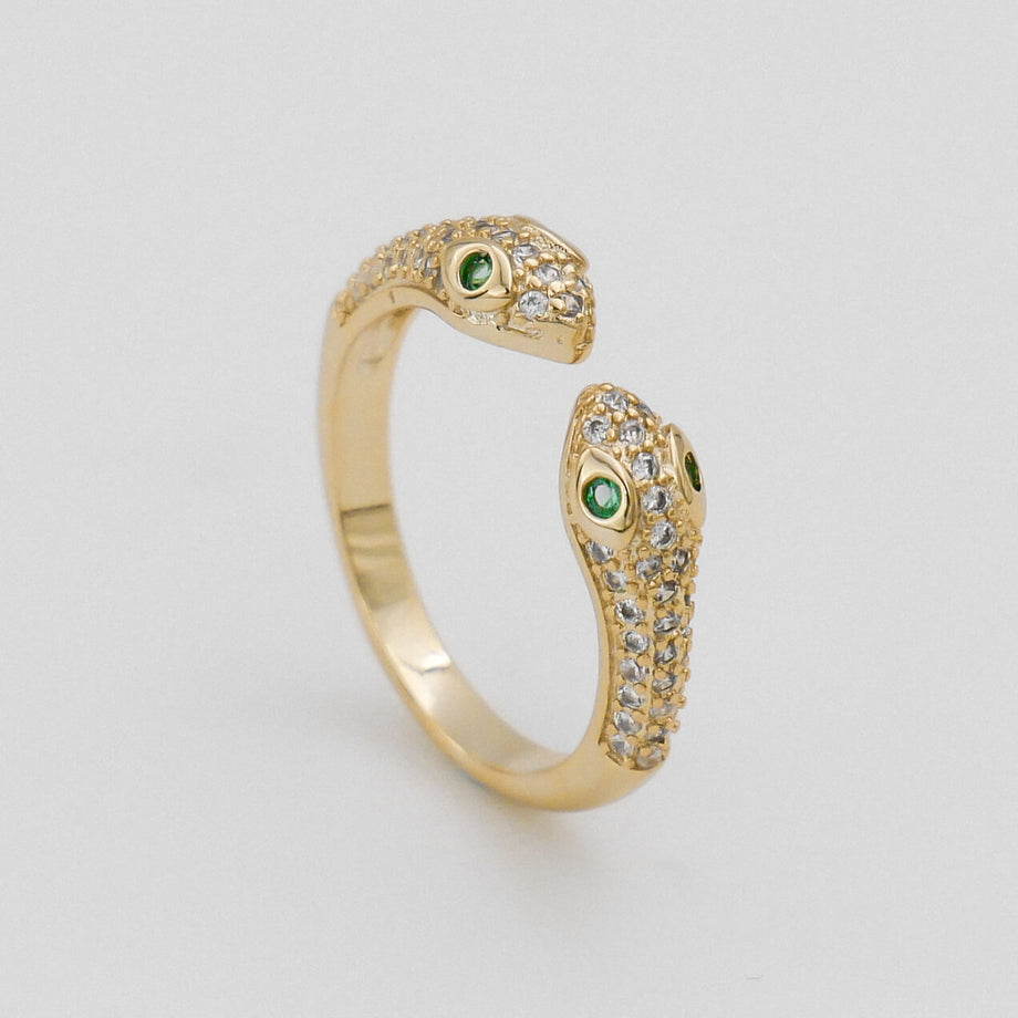 Gold snake ring with green gemstone eyes.